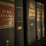 Close-up de livros de direito e legislação organizados em uma estante.
