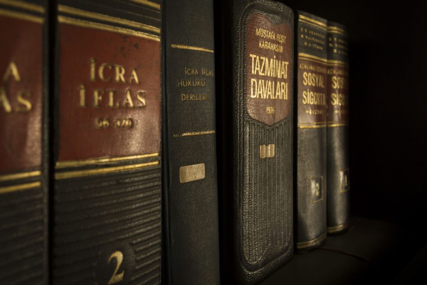 Close-up de livros de direito e legislação organizados em uma estante.