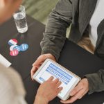 Pessoa utiliza um tablet para se registrar em um posto de votação durante o dia da eleição.