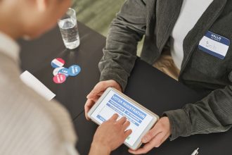 Pessoa utiliza um tablet para se registrar em um posto de votação durante o dia da eleição.