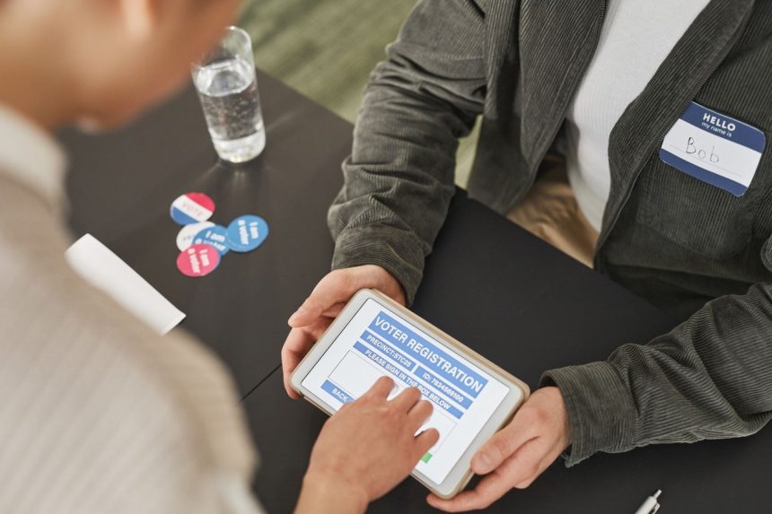 Pessoa utiliza um tablet para se registrar em um posto de votação durante o dia da eleição.