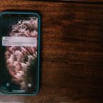Celular exibindo um alerta bancário sobre uma superfície de madeira