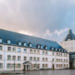 Vista exterior de um edifício histórico de tribunal em Luxemburgo, sob céu nublado.