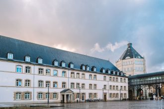 Vista exterior de um edifício histórico de tribunal em Luxemburgo, sob céu nublado.